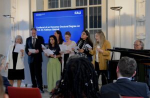 M.A: Human Rights Studierende und Prodekan sowie Prof. Sikkink singen, Prof. Bielfeldt begleitet am Klavier